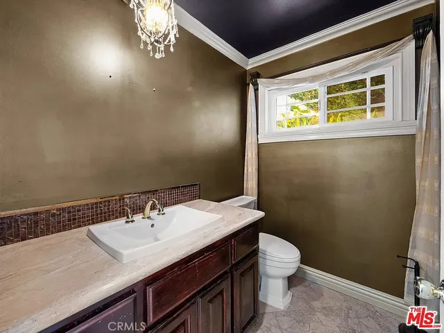 a bathroom with a sink a toilet and a mirror