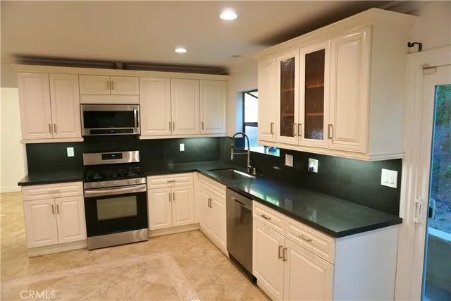 a kitchen with granite countertop a sink and a stove