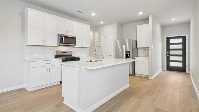 a kitchen with cabinets a sink and appliances