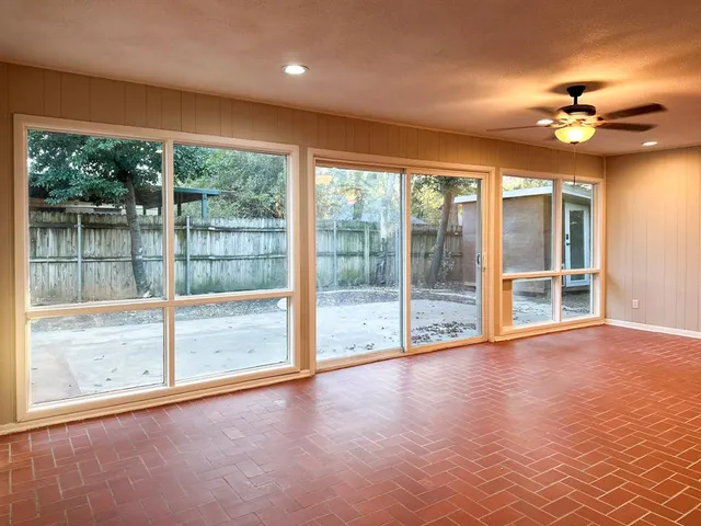a view of an empty room with a floor to ceiling window and wooden floor