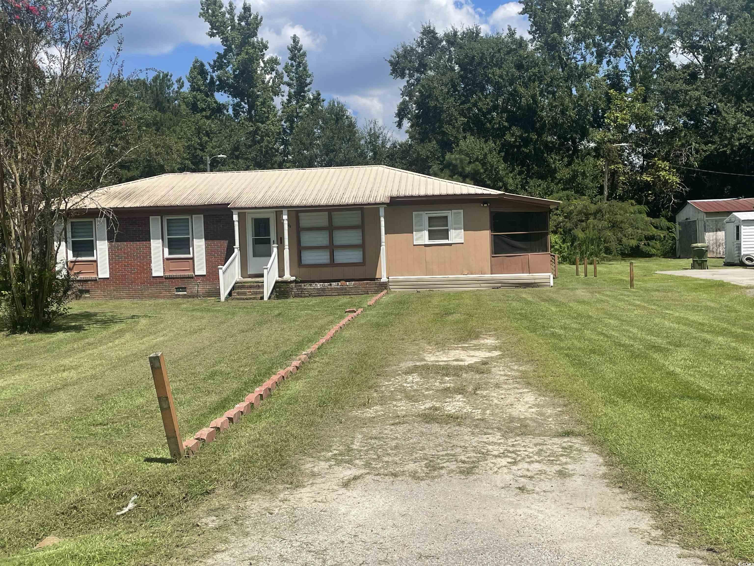 Single story home with a front yard, a metal roof, and entry steps