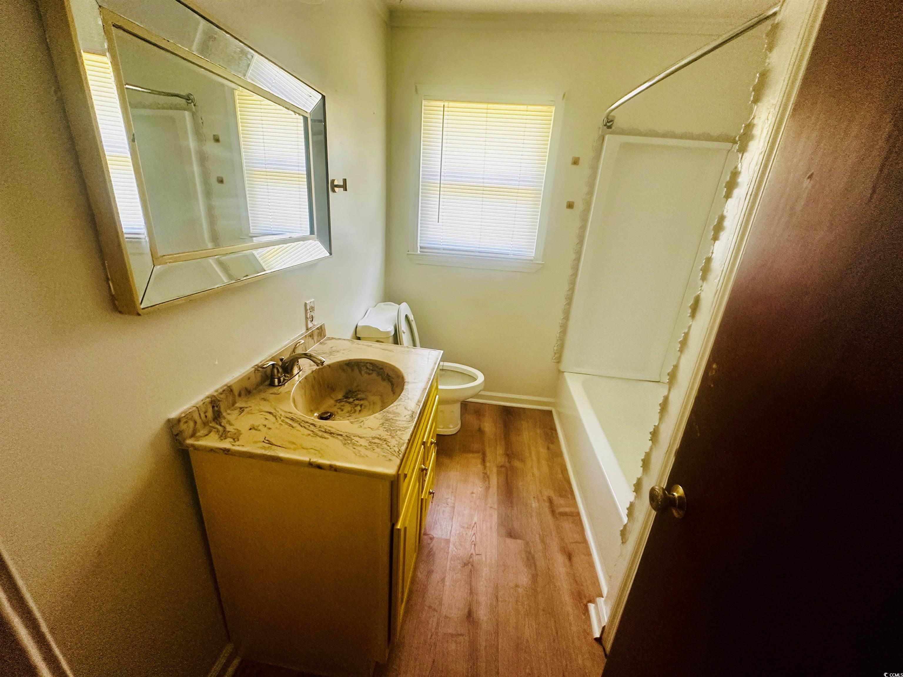 704 West Alder Street Andrews, SC 29510 - Photo 8 of 12 Bathroom with vanity, shower / tub combination, light wood-style floors, and crown molding
