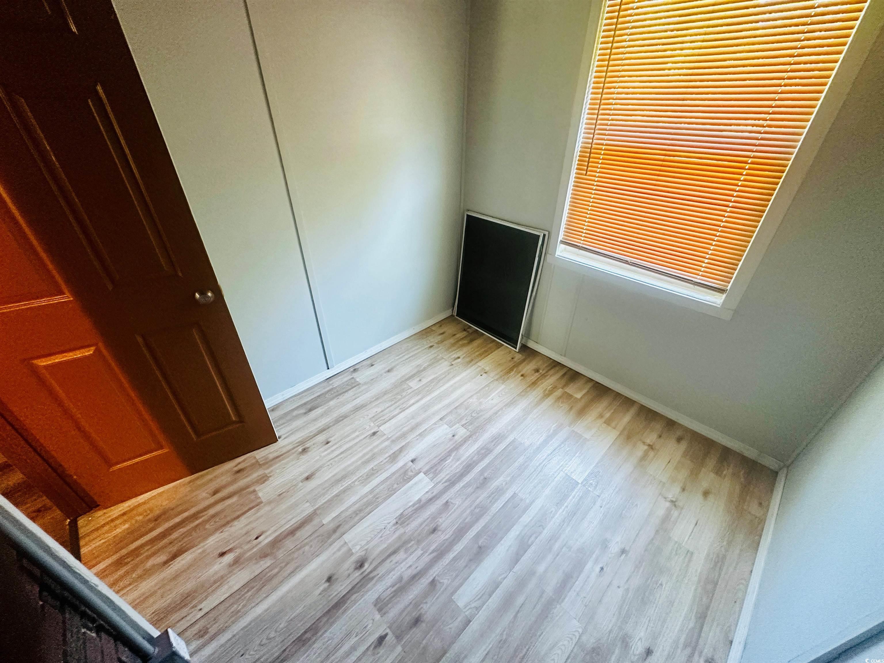 704 West Alder Street Andrews, SC 29510 - Photo 9 of 12 Unfurnished bedroom with light wood finished floors and a closet