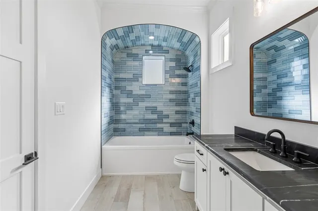 a bathroom with a granite countertop sink a toilet and bathtub