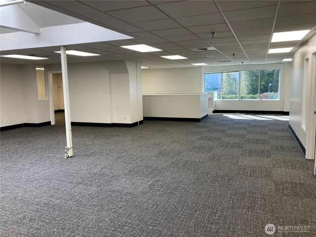 a view of an empty room with closet and entryway