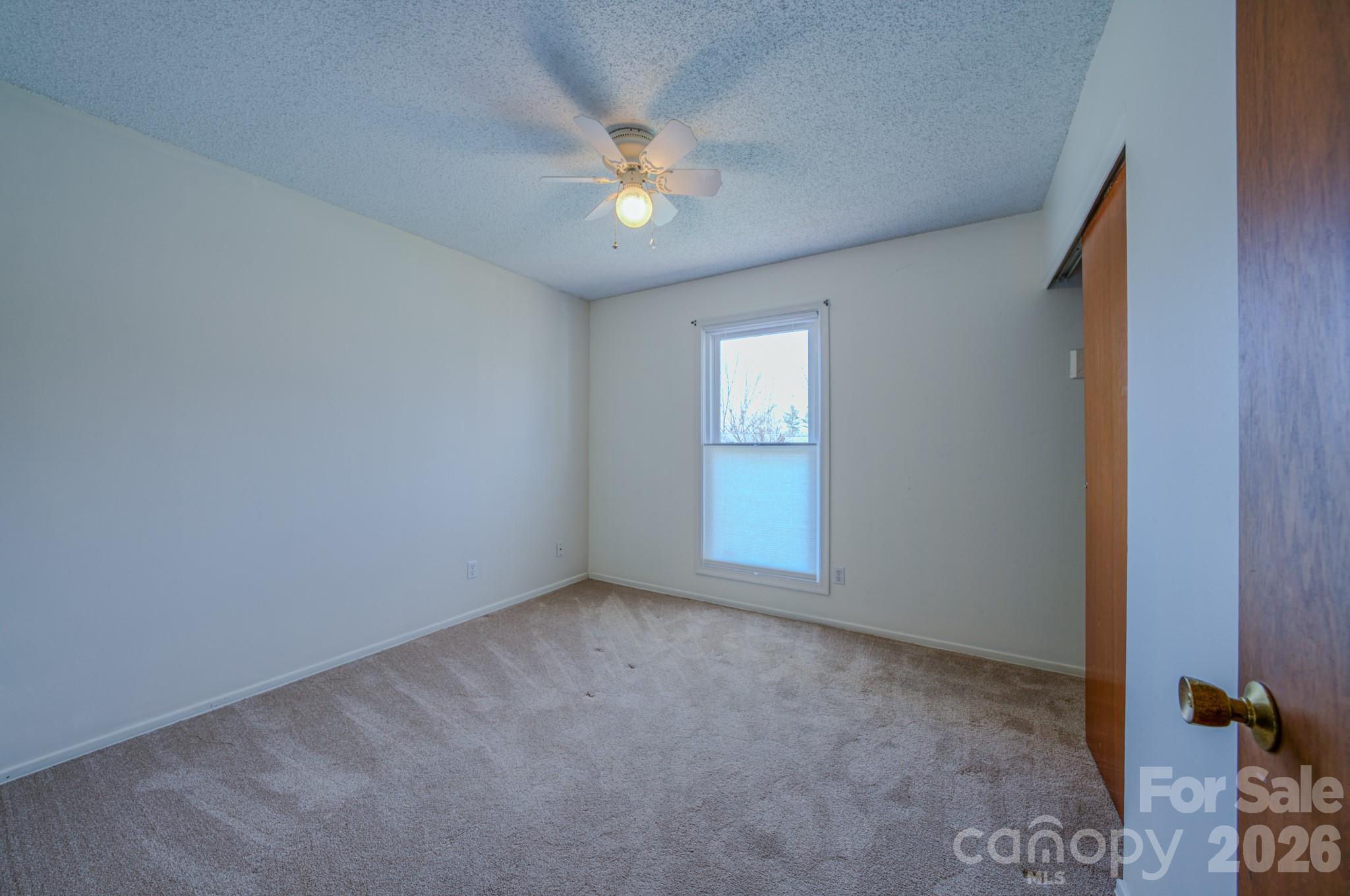 31 Knoll Ridge Drive Asheville, NC 28804 - Photo 18 of 30 an empty room with a chandelier fan and windows