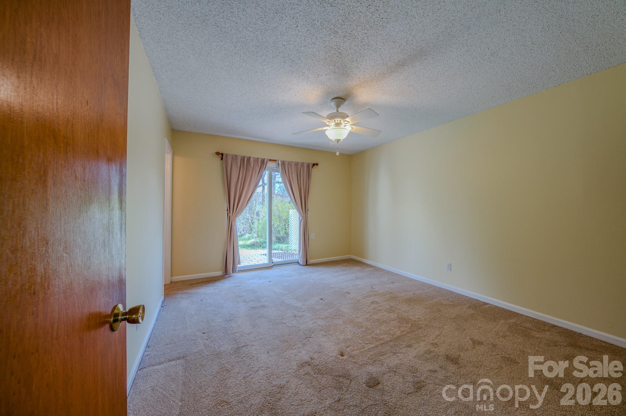 31 Knoll Ridge Drive Asheville, NC 28804 - Photo 20 of 30 an empty room with a chandelier fan and windows