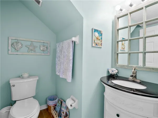 a bathroom with a granite countertop toilet sink and mirror