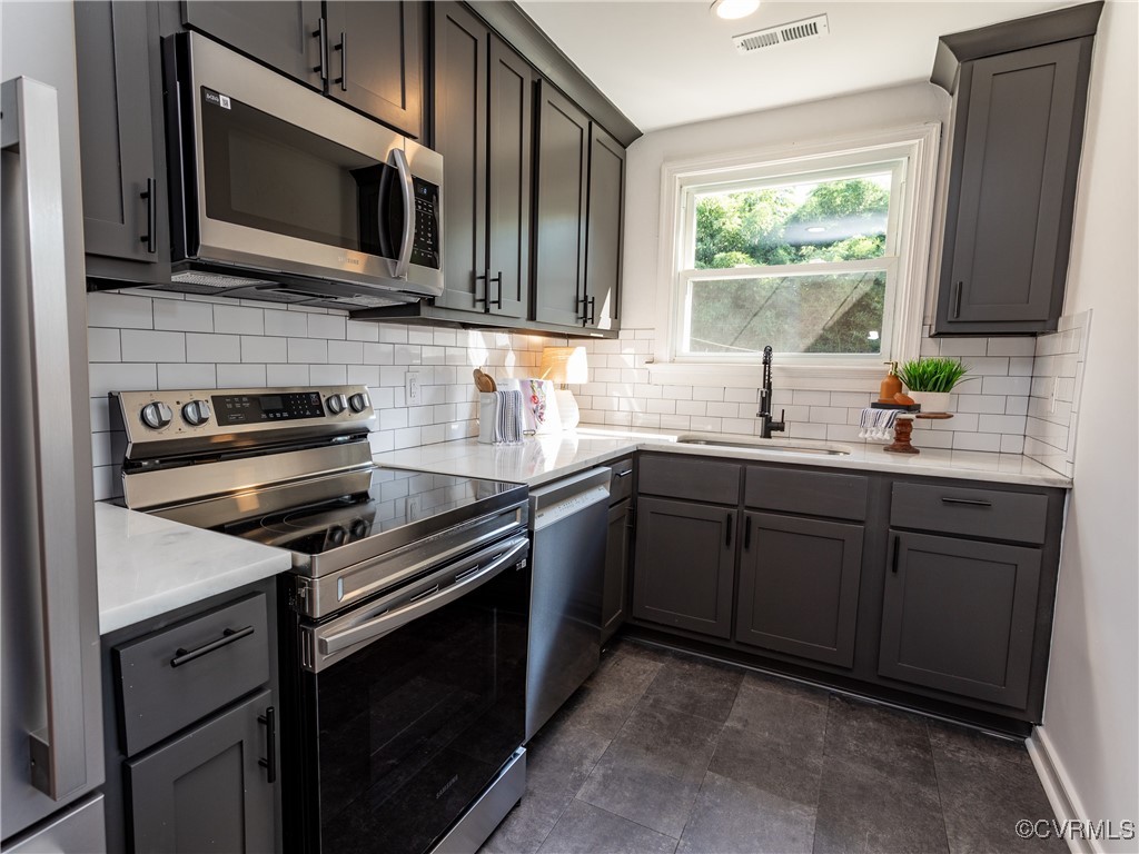 3311 Croydon Road Richmond, VA 23223 - Photo 6 of 23 a kitchen with stainless steel appliances a stove sink microwave and cabinets