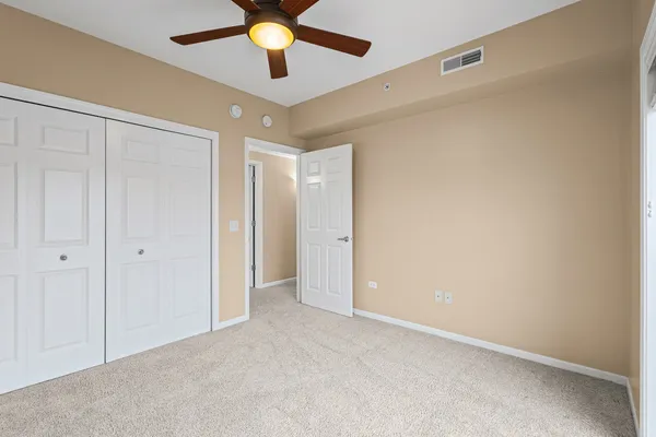 an empty room with a ceiling fan and a fan