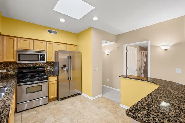 a kitchen with stainless steel appliances granite countertop a stove and a refrigerator