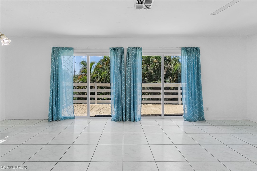 5823 Trout Road Bokeelia, FL 33922 - Photo 10 of 29 a view of an empty room with wooden floor and a window