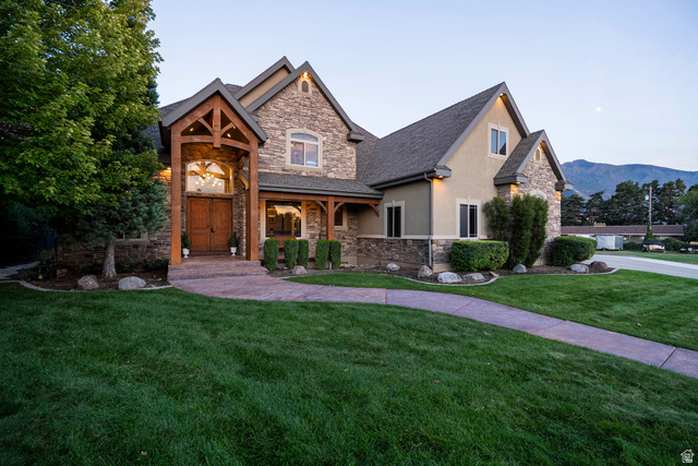 687 South 2080th Street East Springville, UT 84663 - Photo 127 of 149 Stone and stucco exterior featuring a prominent wood-beamed entry, double wood front doors, and a paved walkway