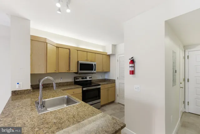 a kitchen with granite countertop a sink and a stove top oven