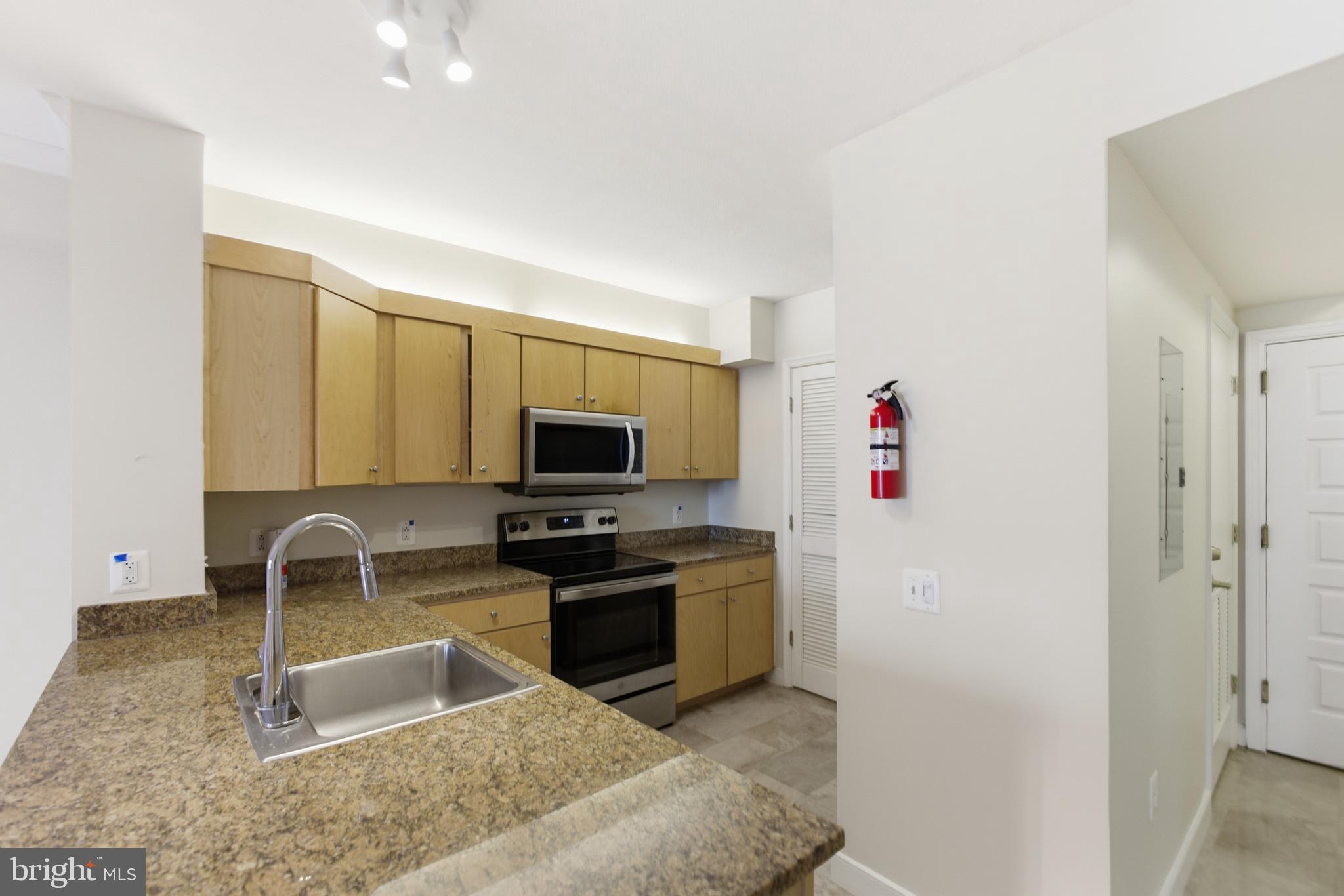 616 E Street Northwest, Unit 419 Washington, DC 20004 - Photo 14 of 30 a kitchen with granite countertop a sink and a stove top oven