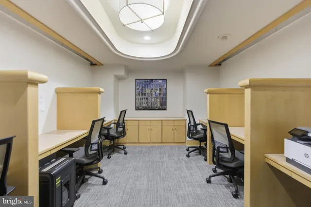 a view of a workspace with furniture and a window
