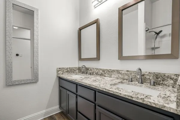a bathroom with a granite countertop sink and a mirror