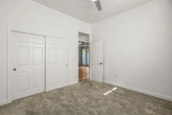 an empty room with closet and windows