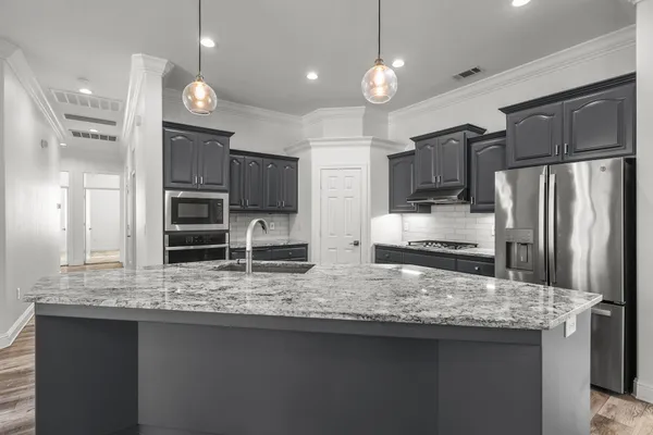 a kitchen with stainless steel appliances granite countertop a sink refrigerator and microwave