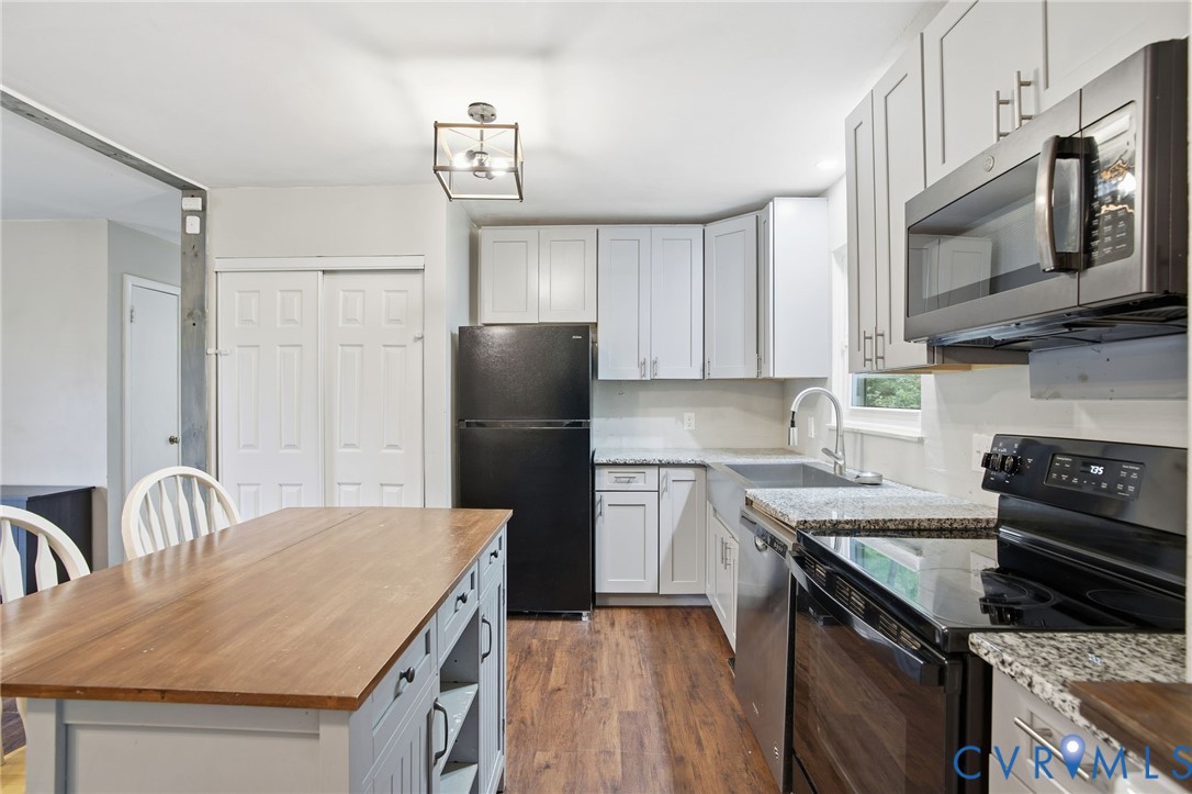 1802 Freeman Street Hopewell, VA 23860 - Photo 7 of 20 a kitchen with stainless steel appliances granite countertop a refrigerator a stove top oven a sink dishwasher and white cabinets with wooden floor