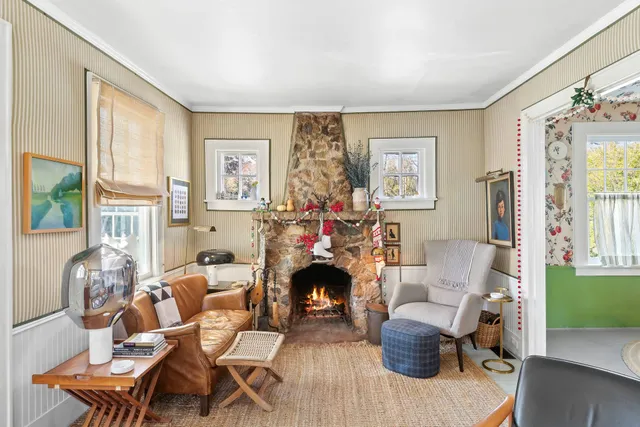 a living room with fireplace furniture and a large window