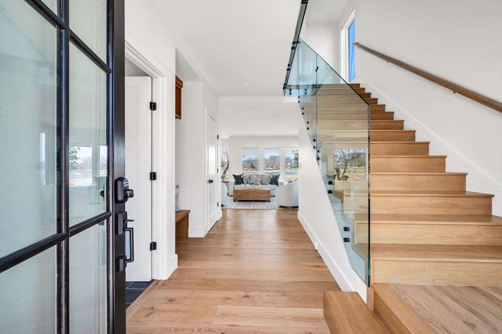 10 Chestnut Place Hingham, MA 02043 - Photo 10 of 32 a view of a hallway to a house with wooden floor and staircase