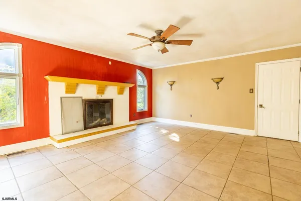a view of an empty room with a fireplace and a window