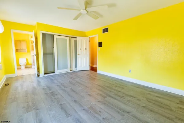 a view of a big room with wooden floor and windows