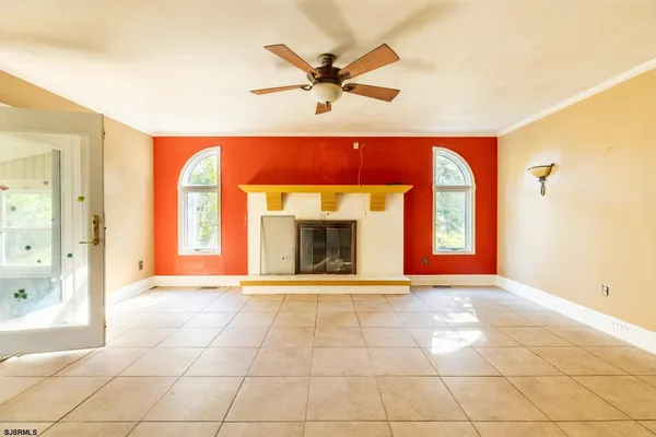 a view of an empty room with a fireplace and a window
