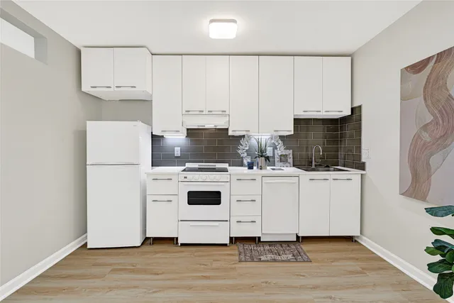 a kitchen with white cabinets and white appliances