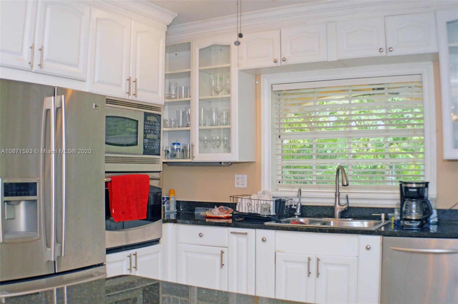 6500 Southwest 148th Avenue Southwest Ranches, FL 33330 - Photo 4 of 25 a kitchen with granite countertop a stove a sink and a microwave