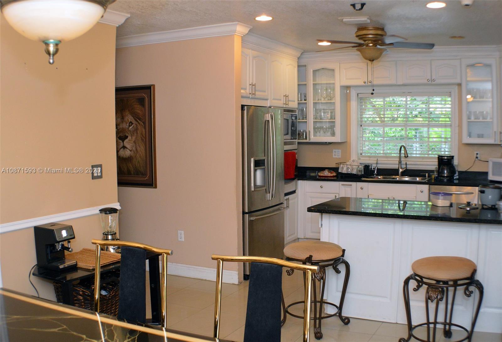6500 Southwest 148th Avenue Southwest Ranches, FL 33330 - Photo 5 of 25 a kitchen with stainless steel appliances granite countertop sink microwave and wooden floor
