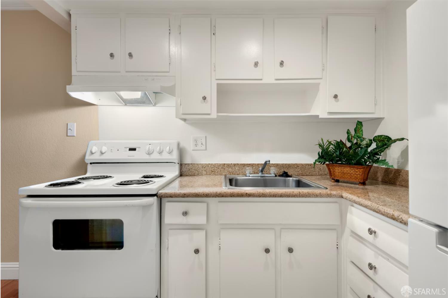 1736 Woodland Avenue Palo Alto, CA 94301 - Photo 7 of 17 a kitchen with granite countertop a sink a stove and cabinets