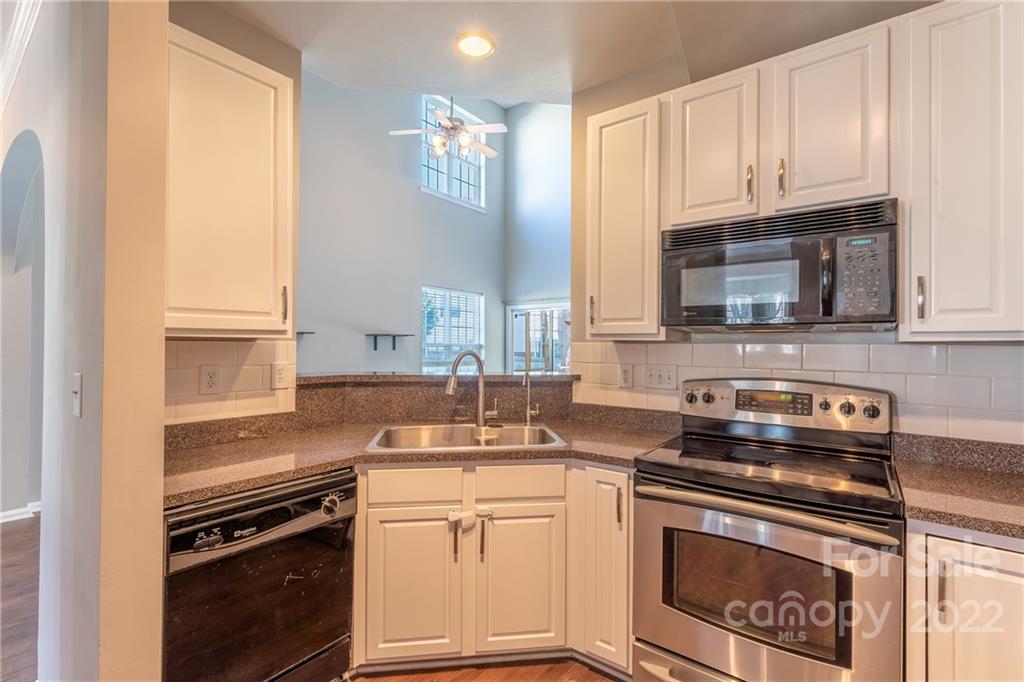 3941 Caliper Place Fort Mill, SC 29708 - Photo 8 of 46 a kitchen with granite countertop a stove top oven microwave and cabinets