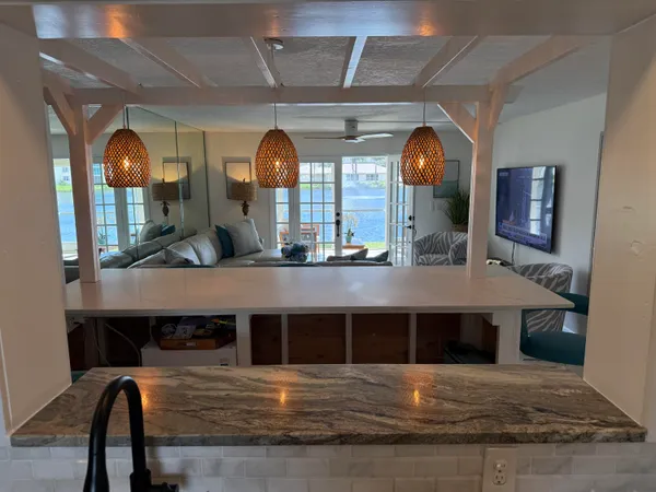 a living room with furniture floor to ceiling window and a flat screen tv
