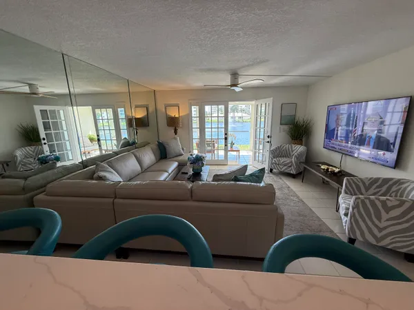 a living room with patio furniture and a large window
