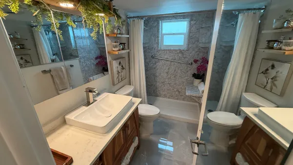 a bedroom with a bed and a mirror on dresser