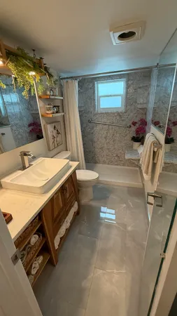 a living room with a toilet a flat screen tv and a large window