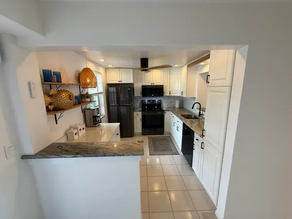 a kitchen with stainless steel appliances a stove refrigerator and microwave