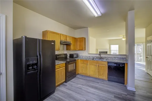 a kitchen with stainless steel appliances granite countertop a refrigerator and a stove top oven