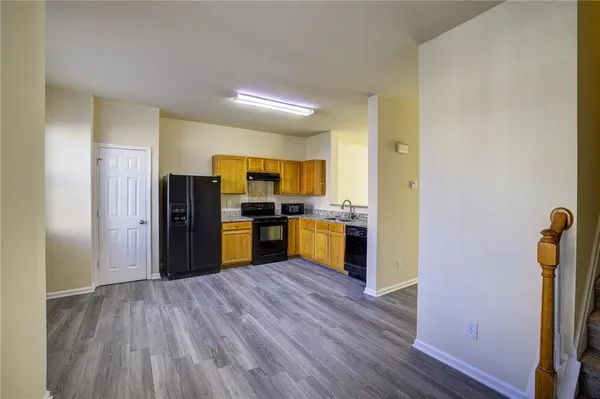 a kitchen with stainless steel appliances a refrigerator and wooden floor