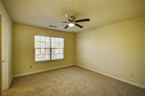 an empty room with a window and a ceiling fan