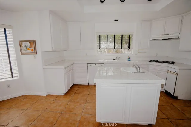a kitchen with a sink cabinets appliances and a window