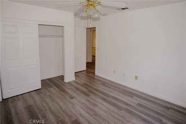 a view of a hallway with wooden floor and a chandelier