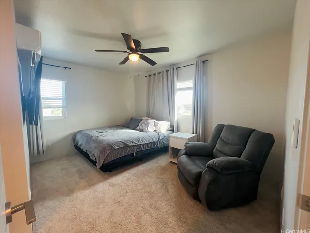 a bedroom with bed couch and window