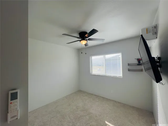 an empty room with a ceiling fan and window
