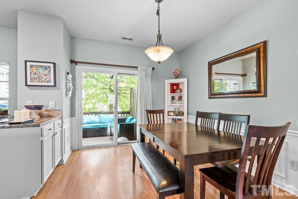 8109 Rhiannon Road Raleigh, NC 27613 - Photo 7 of 11 a view of a dining room with furniture a chandelier and wooden floor