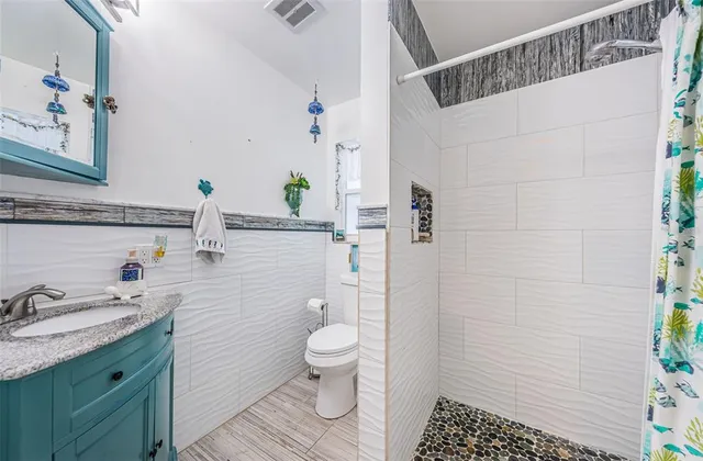 a bathroom with a sink a toilet and shower