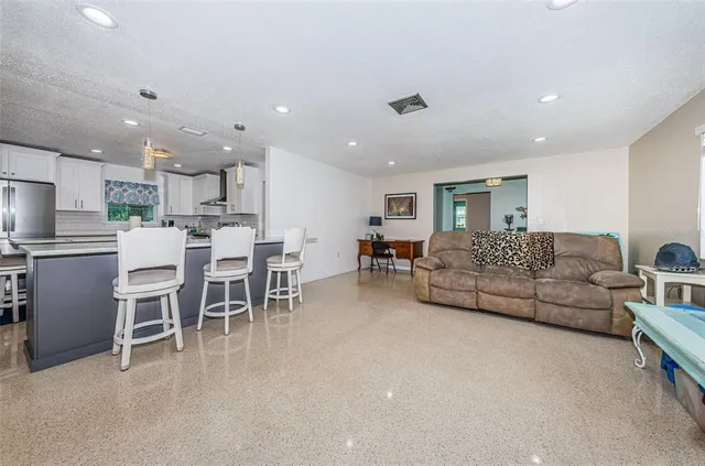 a living room with furniture and kitchen view