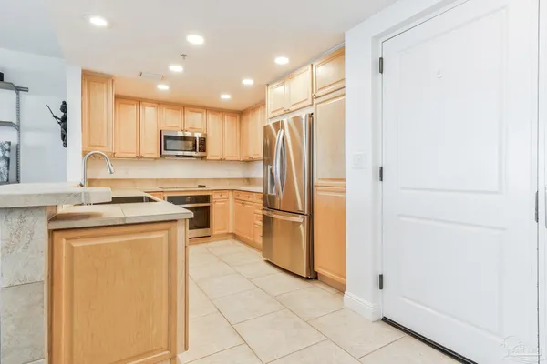 a kitchen with stainless steel appliances granite countertop a refrigerator and a stove top oven